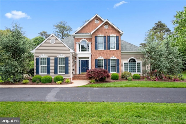 view of front of home featuring a front yard and brick siding