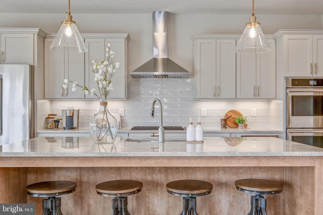 101 Eagle Dr, Broomall, PA 19008 - kitchen featuring stainless steel double oven, wall chimney exhaust hood, decorative backsplash, and a kitchen bar