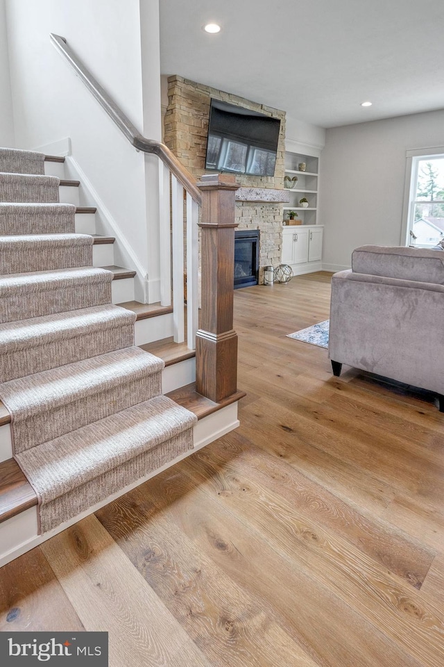 101 Eagle Dr, Broomall, PA 19008 - stairs featuring wood finished floors, a fireplace, recessed lighting, baseboards, and built in shelves