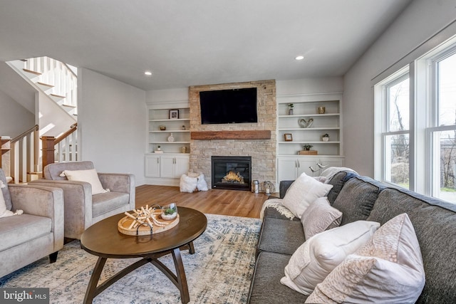 101 Eagle Dr, Broomall, PA 19008 - living area with wood finished floors, stairway, a stone fireplace, built in shelves, and recessed lighting