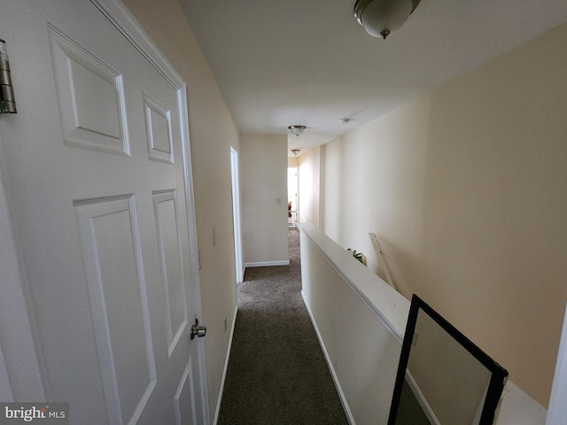 corridor with dark carpet and baseboards