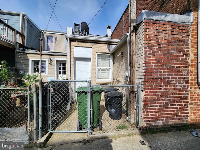 view of front facade featuring a gate, brick siding, and cooling unit