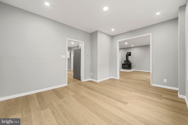 97 Church St, Thorofare, NJ 08086 - empty room featuring a wood stove, light wood-style flooring, baseboards, and recessed lighting