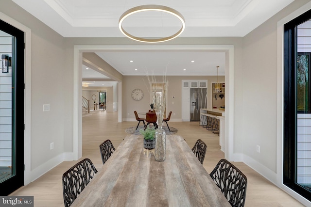 7916 Lewinsville Rd, Mclean, VA 22102 - dining space featuring light wood-type flooring, a raised ceiling, baseboards, recessed lighting, and crown molding