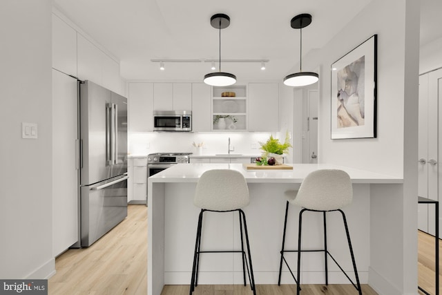 2939 Van Ness St NW Unit 424, Washington, DC 20008 - kitchen featuring appliances with stainless steel finishes, a sink, a kitchen breakfast bar, and light countertops