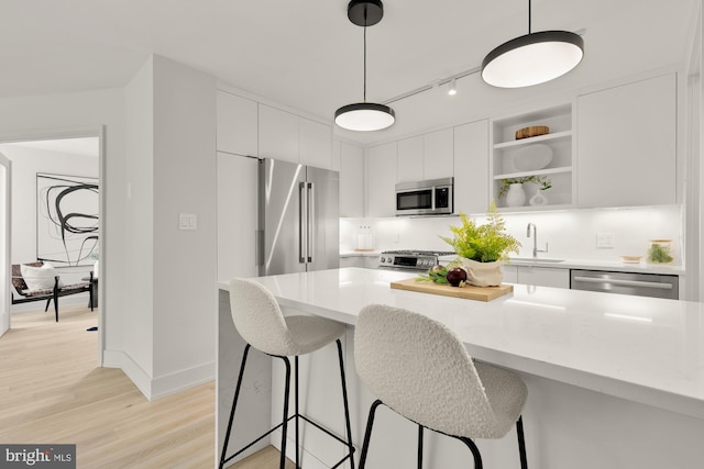 2939 Van Ness St NW Unit 424, Washington, DC 20008 - kitchen with appliances with stainless steel finishes, a sink, white cabinets, and a kitchen breakfast bar
