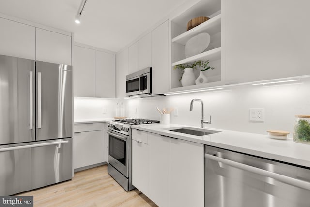 2939 Van Ness St NW Unit 424, Washington, DC 20008 - kitchen with stainless steel appliances, a sink, light countertops, white cabinetry, and modern cabinets