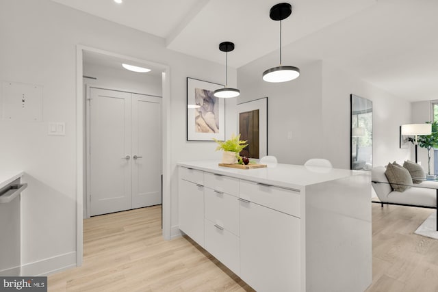 2939 Van Ness St NW Unit 424, Washington, DC 20008 - kitchen with white cabinets, light wood-style flooring, light countertops, and hanging light fixtures