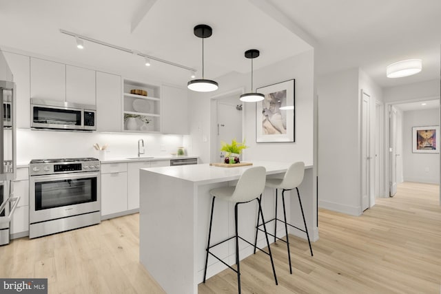 2939 Van Ness St NW Unit 424, Washington, DC 20008 - kitchen featuring appliances with stainless steel finishes, white cabinetry, modern cabinets, and open shelves