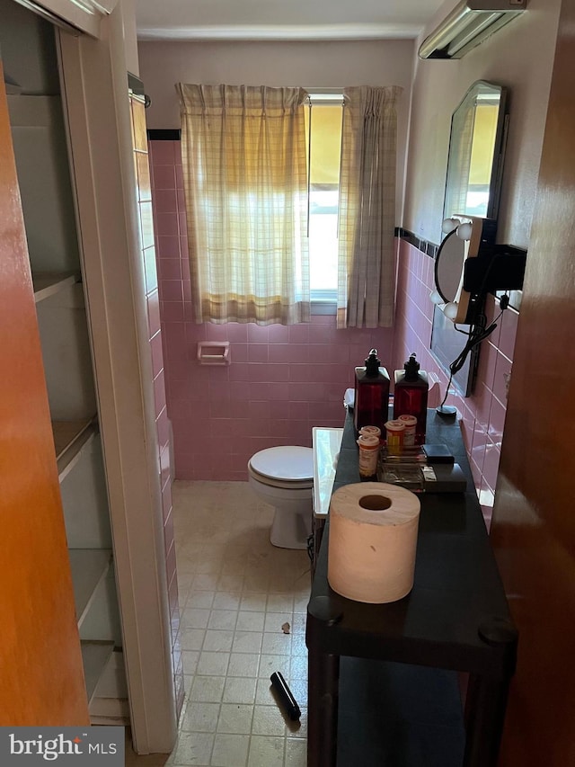 bathroom with tile walls and toilet