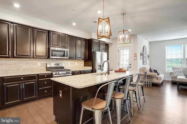 10117 Fosset St, Ijamsville, MD 21754 - kitchen featuring stainless steel appliances, a sink, a kitchen breakfast bar, light wood-style flooring, and tasteful backsplash