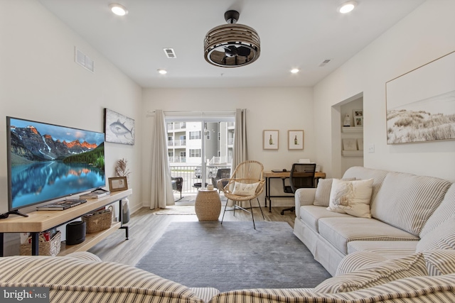 living area featuring wood finished floors, recessed lighting, and baseboards