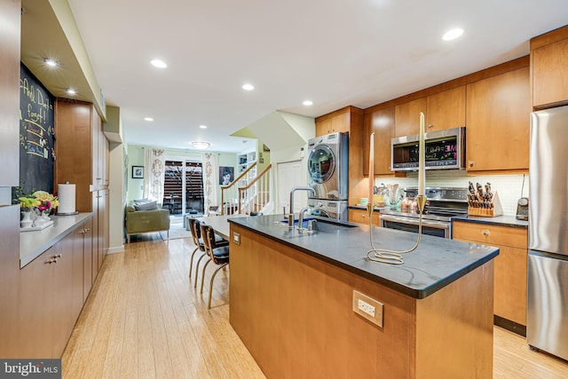 1702 Seaton St NW, Washington, DC 20009 - kitchen with stainless steel appliances, a sink, stacked washer and clothes dryer, dark countertops, and recessed lighting