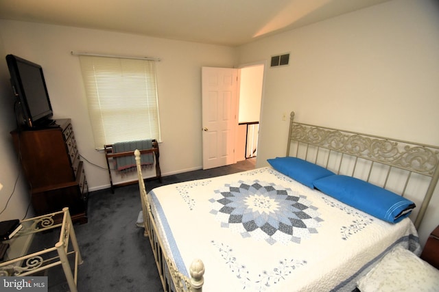 bedroom with dark colored carpet and baseboards