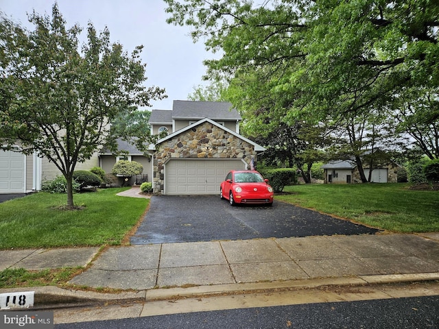 view of front of house with stone siding, driveway, a front yard, and an attached garage