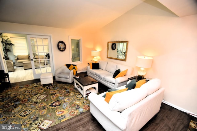 living area featuring wood finished floors, vaulted ceiling, and baseboards