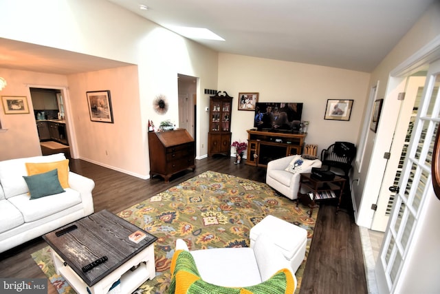 living room with wood finished floors, baseboards, and high vaulted ceiling
