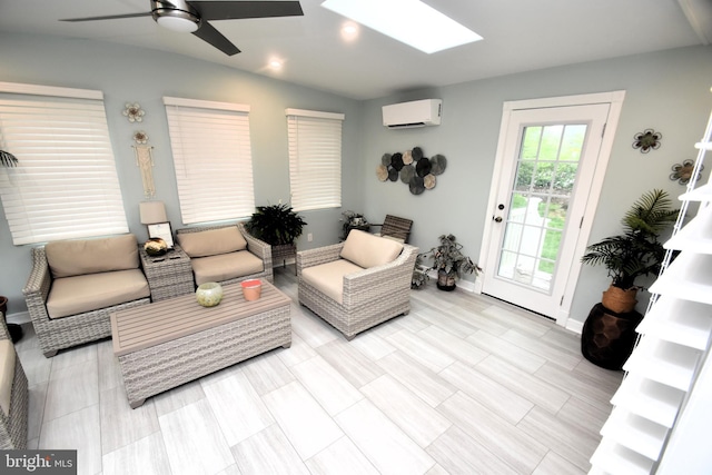 living area with a skylight, a ceiling fan, a wall mounted air conditioner, baseboards, and recessed lighting