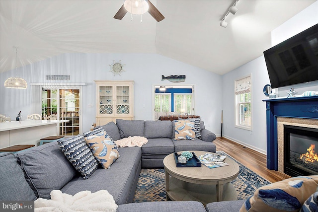 4 Abbey Cir, Ocean Pines, MD 21811 - living area with vaulted ceiling, wood finished floors, ceiling fan, plenty of natural light, and a glass covered fireplace