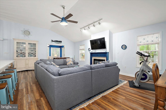 4 Abbey Cir, Ocean Pines, MD 21811 - living room featuring a ceiling fan, dark wood-type flooring, vaulted ceiling, rail lighting, and a glass covered fireplace