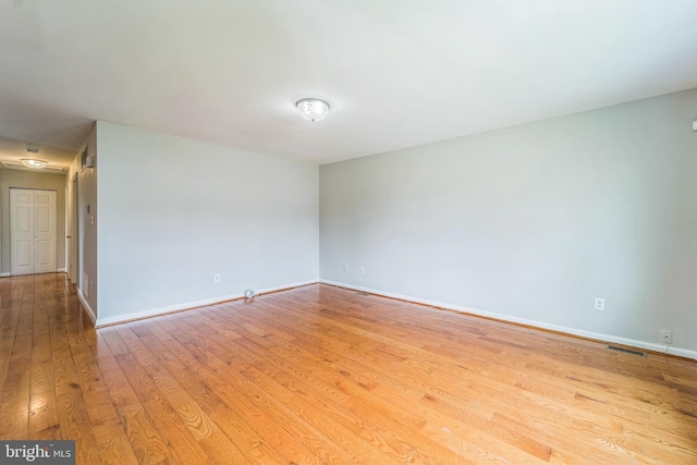 empty room with hardwood / wood-style flooring and baseboards