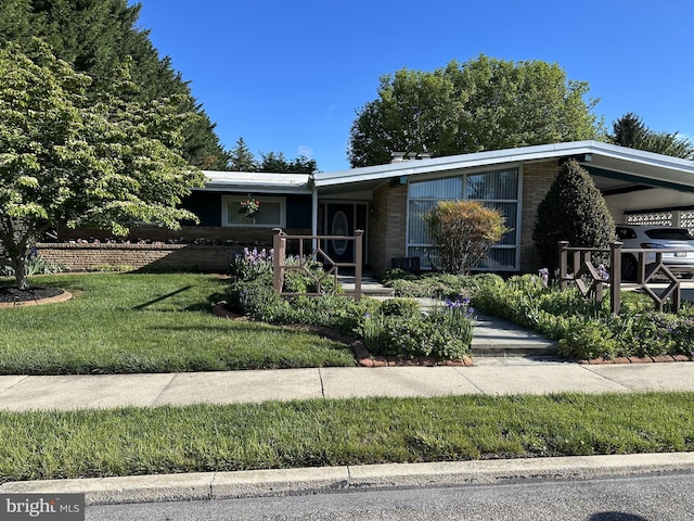 view of front facade featuring brick siding and a front yard
