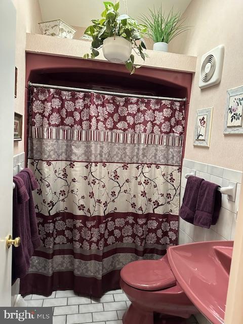 100 W Ave, Hanover, PA 17331 - full bath featuring a sink, tile patterned flooring, tile walls, toilet, and a shower with curtain