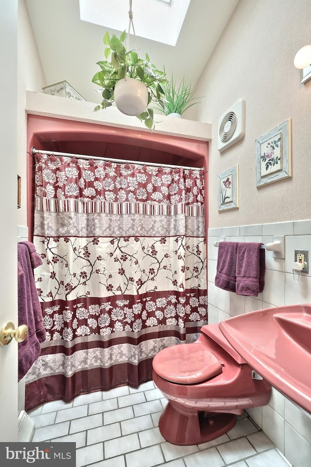 100 W Ave, Hanover, PA 17331 - bathroom with a skylight, tile patterned floors, tile walls, curtained shower, and toilet