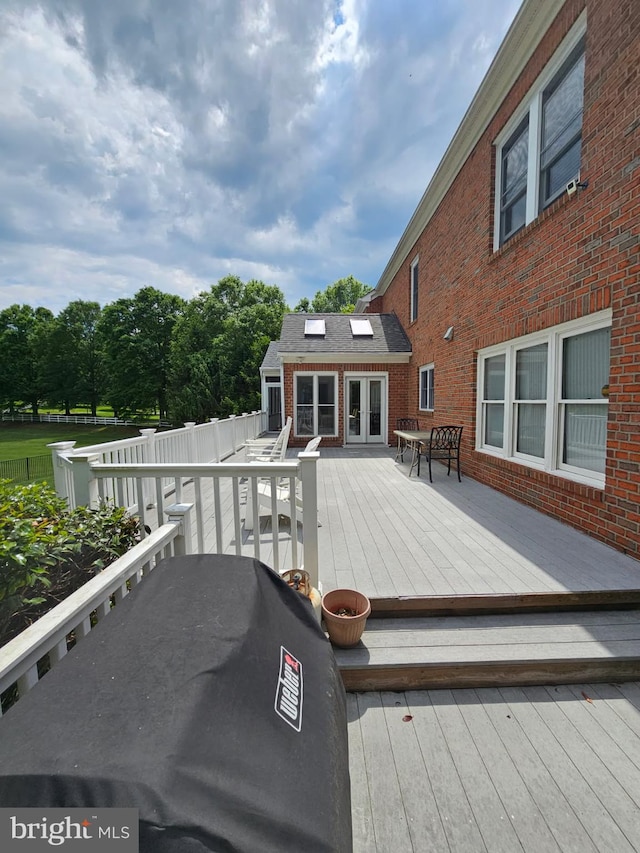 deck featuring area for grilling, french doors, outdoor dining area, and fence
