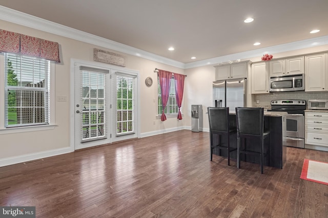 2005 Golden Ct, Mechanicsburg, PA 17055 - kitchen featuring appliances with stainless steel finishes, crown molding, dark wood-style floors, a kitchen bar, and backsplash