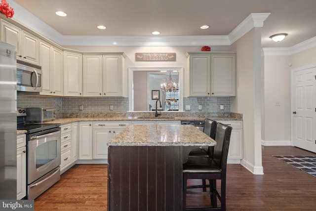 2005 Golden Ct, Mechanicsburg, PA 17055 - kitchen with stainless steel appliances, a sink, a breakfast bar, a center island, and ornamental molding
