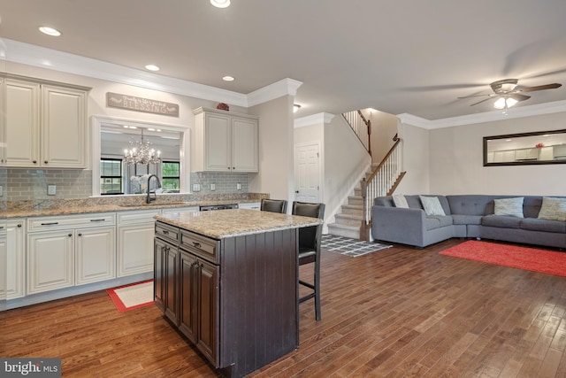 2005 Golden Ct, Mechanicsburg, PA 17055 - kitchen featuring a sink, a kitchen breakfast bar, open floor plan, dark wood-style floors, and crown molding