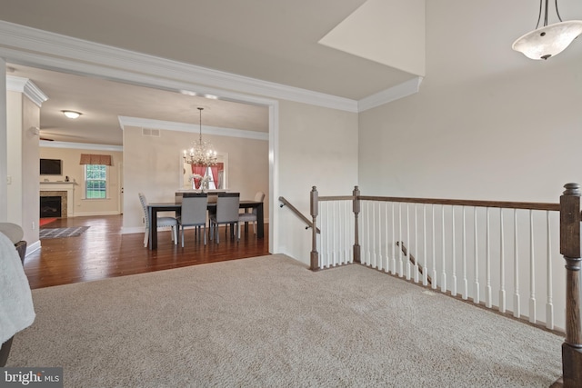 2005 Golden Ct, Mechanicsburg, PA 17055 - dining space with carpet floors, crown molding, a chandelier, a fireplace, and wood finished floors
