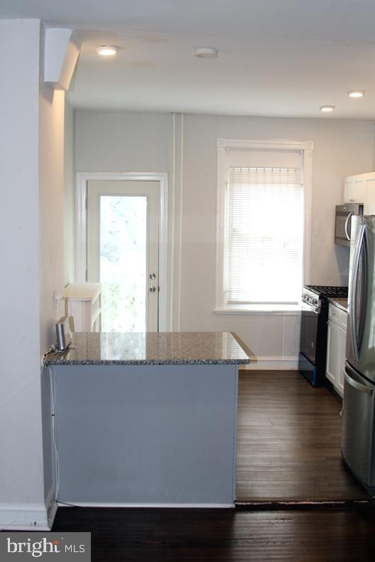 126 N Sickels St, Philadelphia, PA 19139 - kitchen featuring stainless steel appliances, white cabinets, dark stone counters, a peninsula, and recessed lighting