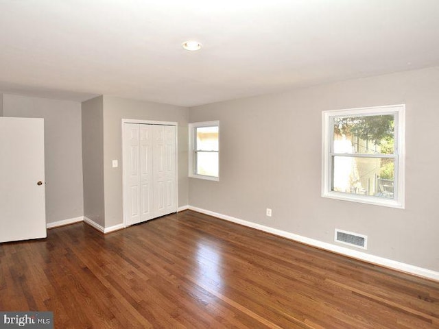 2626 12th St S Unit 1, Arlington, VA 22204 - unfurnished bedroom with baseboards, multiple windows, wood finished floors, and a closet