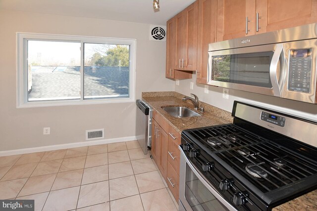 2626 12th St S Unit 1, Arlington, VA 22204 - kitchen with stainless steel appliances, a sink, baseboards, light tile patterned floors, and brown cabinets