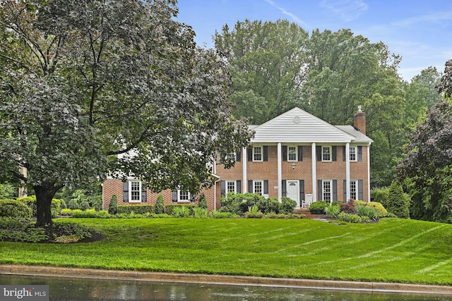 11904 Paradise Ln, Herndon, VA 20171 - greek revival house featuring a front lawn, brick siding, and a chimney