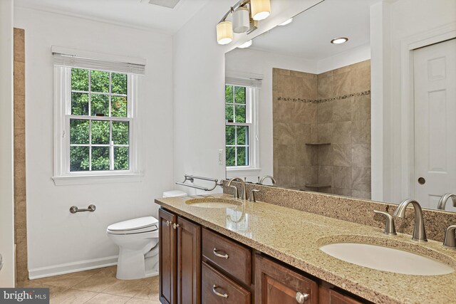 11904 Paradise Ln, Herndon, VA 20171 - bathroom featuring double vanity, toilet, baseboards, tile patterned flooring, and a tile shower