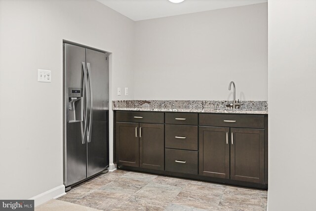 11904 Paradise Ln, Herndon, VA 20171 - kitchen featuring stainless steel fridge with ice dispenser, dark brown cabinetry, light stone countertops, and a sink