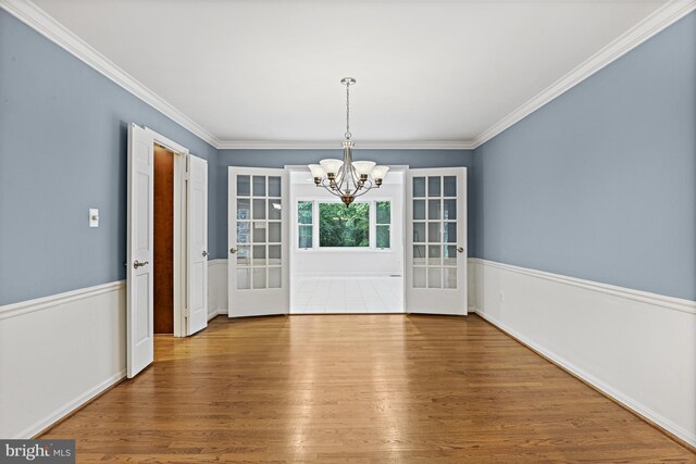 11904 Paradise Ln, Herndon, VA 20171 - unfurnished dining area featuring a chandelier, wood finished floors, ornamental molding, and french doors