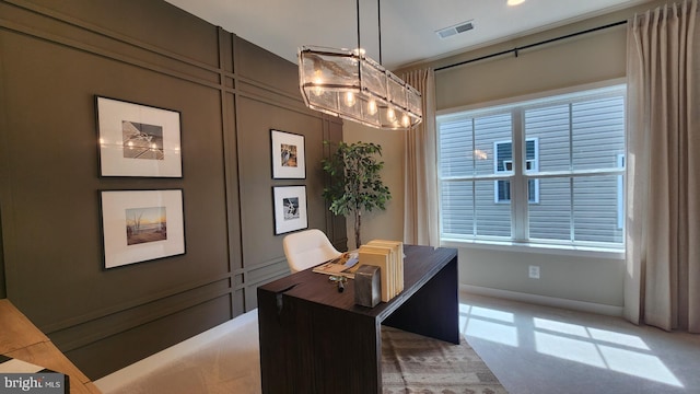 office space with light colored carpet and a chandelier