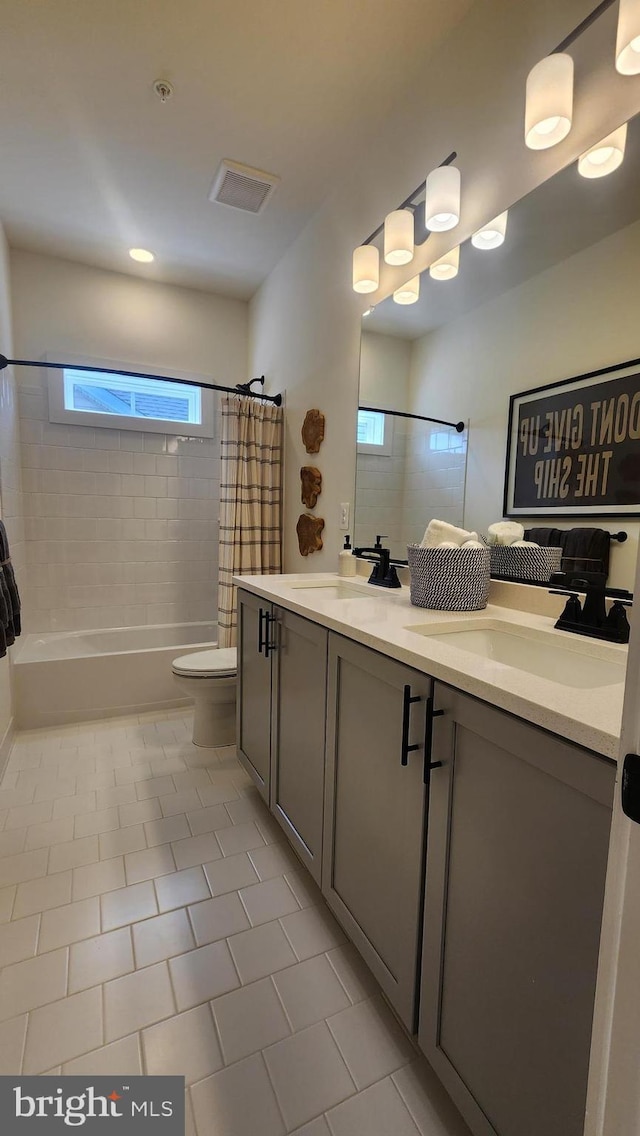 full bath with shower / bath combo with shower curtain, tile patterned floors, toilet, and double vanity