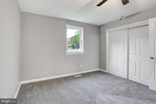 unfurnished bedroom with carpet flooring, baseboards, and a closet