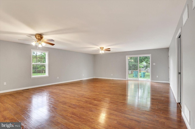 spare room featuring a ceiling fan, wood finished floors, and baseboards