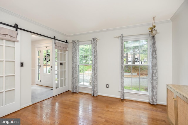 1015 E Macphail, Bel Air, MD 21015 - unfurnished dining area with a barn door, light wood-type flooring, ornamental molding, and baseboards