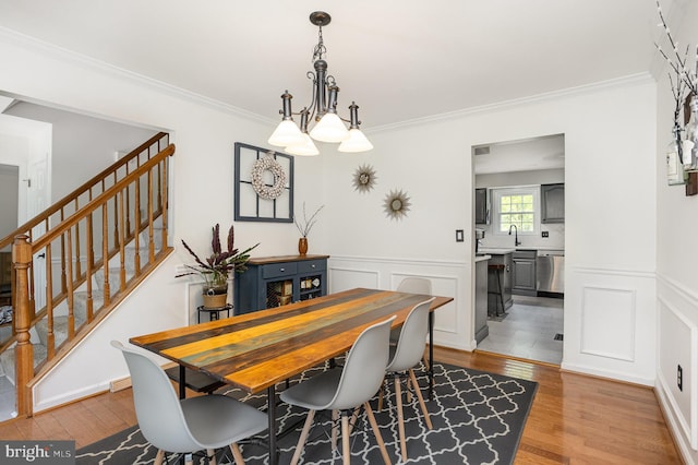 1015 E Macphail, Bel Air, MD 21015 - dining area featuring light wood finished floors, a chandelier, stairway, a wainscoted wall, and ornamental molding