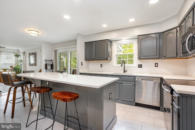 1015 E Macphail, Bel Air, MD 21015 - kitchen featuring stainless steel appliances, gray cabinetry, a sink, a breakfast bar, and backsplash