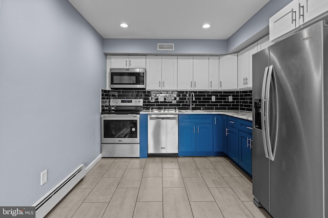kitchen featuring appliances with stainless steel finishes, a baseboard heating unit, blue cabinetry, a sink, and white cabinetry