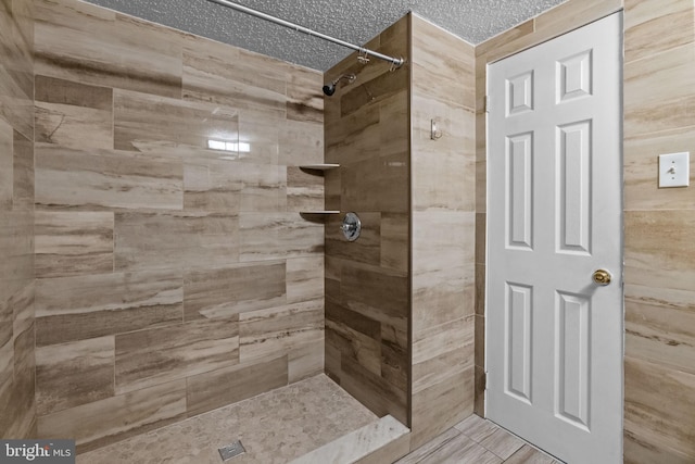 bathroom featuring a tile shower and a textured ceiling