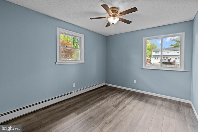 empty room featuring a baseboard radiator, healthy amount of natural light, wood finished floors, a textured ceiling, and ceiling fan